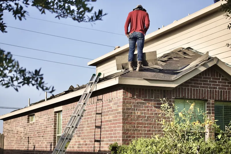 Professional roofer working on a residential roof in Farmington Acres